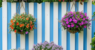 white and blue garden fence with colorful hanging baskets and flowers