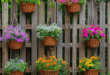 wood garden fence with colorful hanging baskets